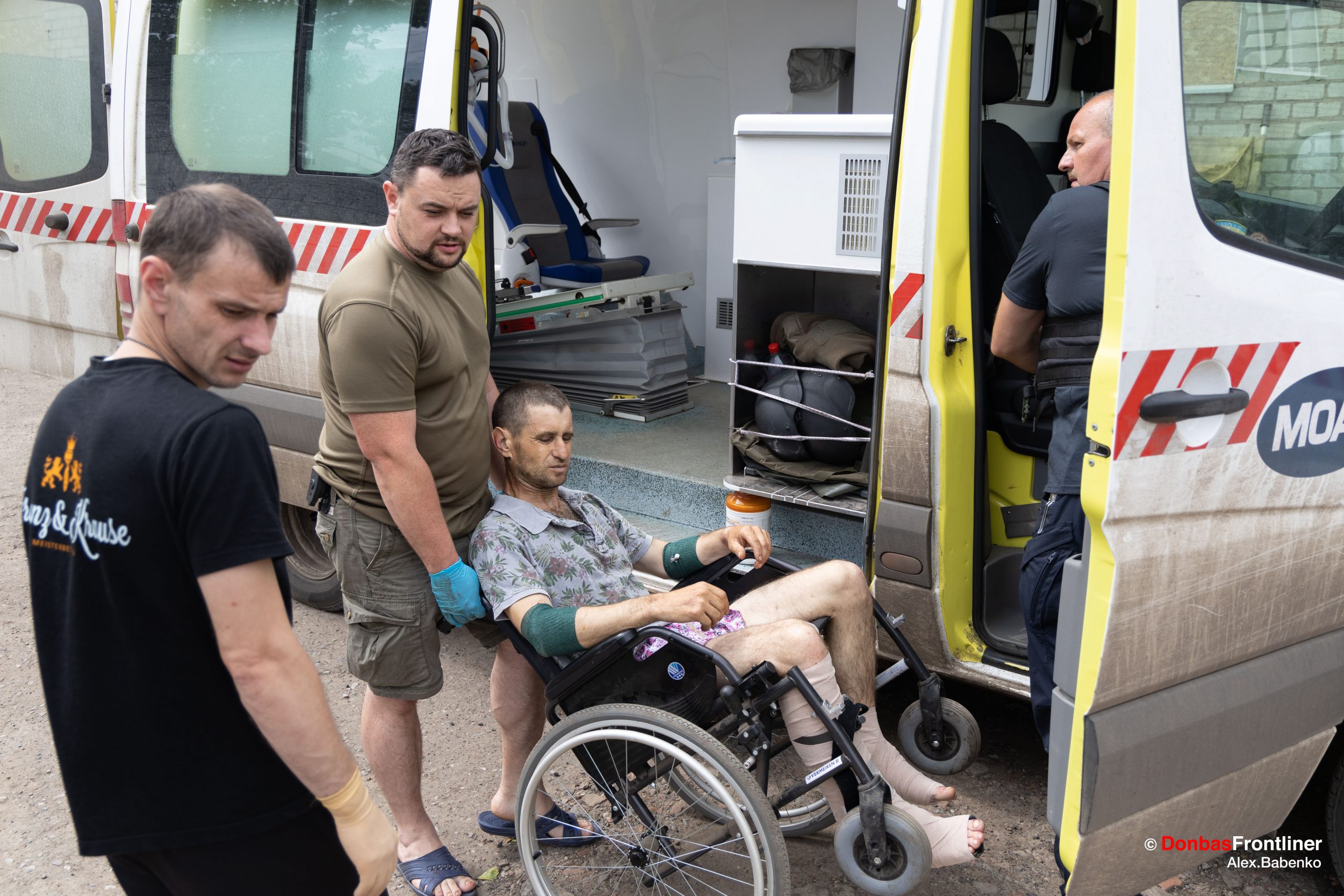 Donbas Frontliner / Лікар Володимир готує до посадки в машину медичної евакуації пораненого Андрія