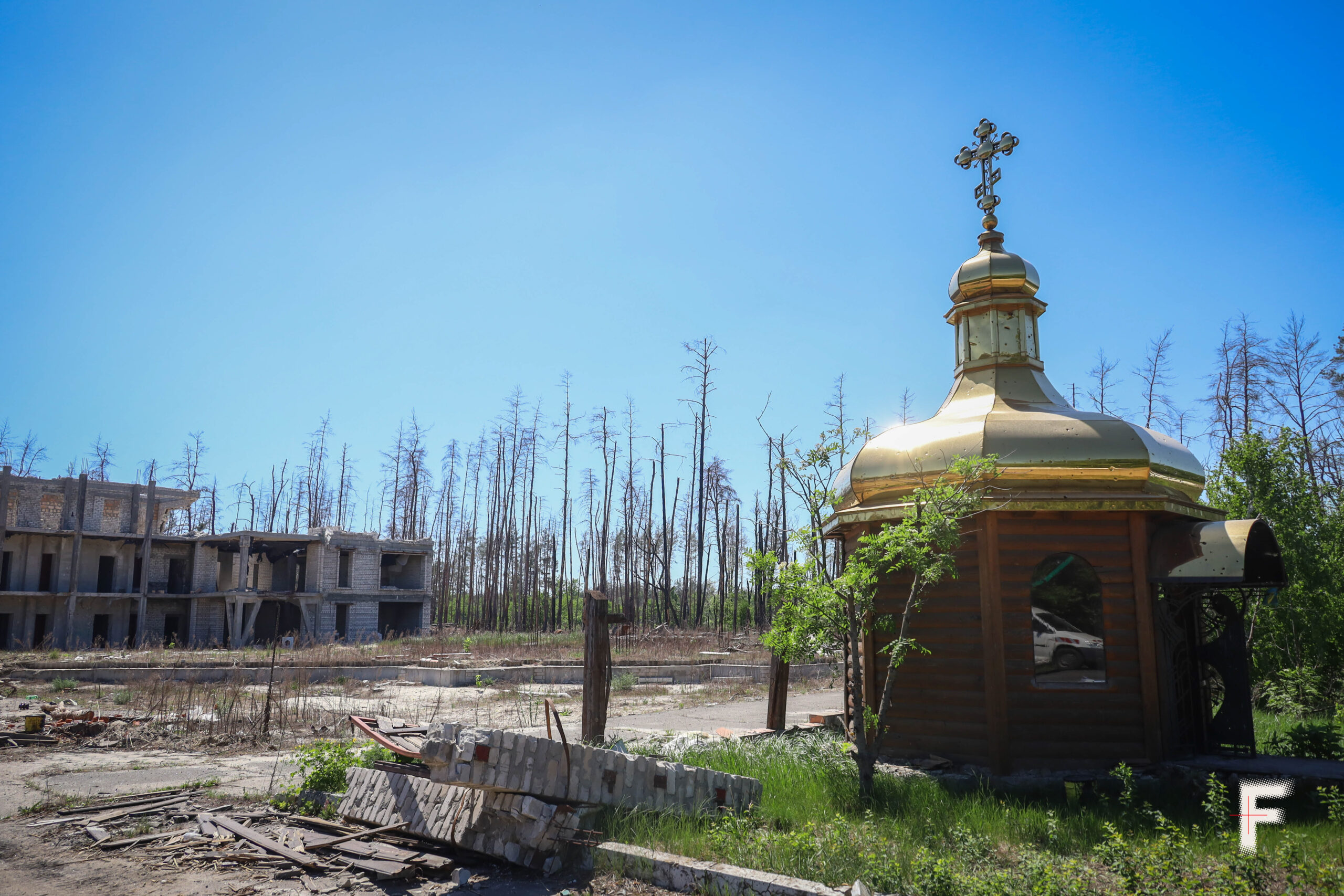 Знищена капличка на фоні недобудованого туристичного комплексу та спаленого Лиманського лісу