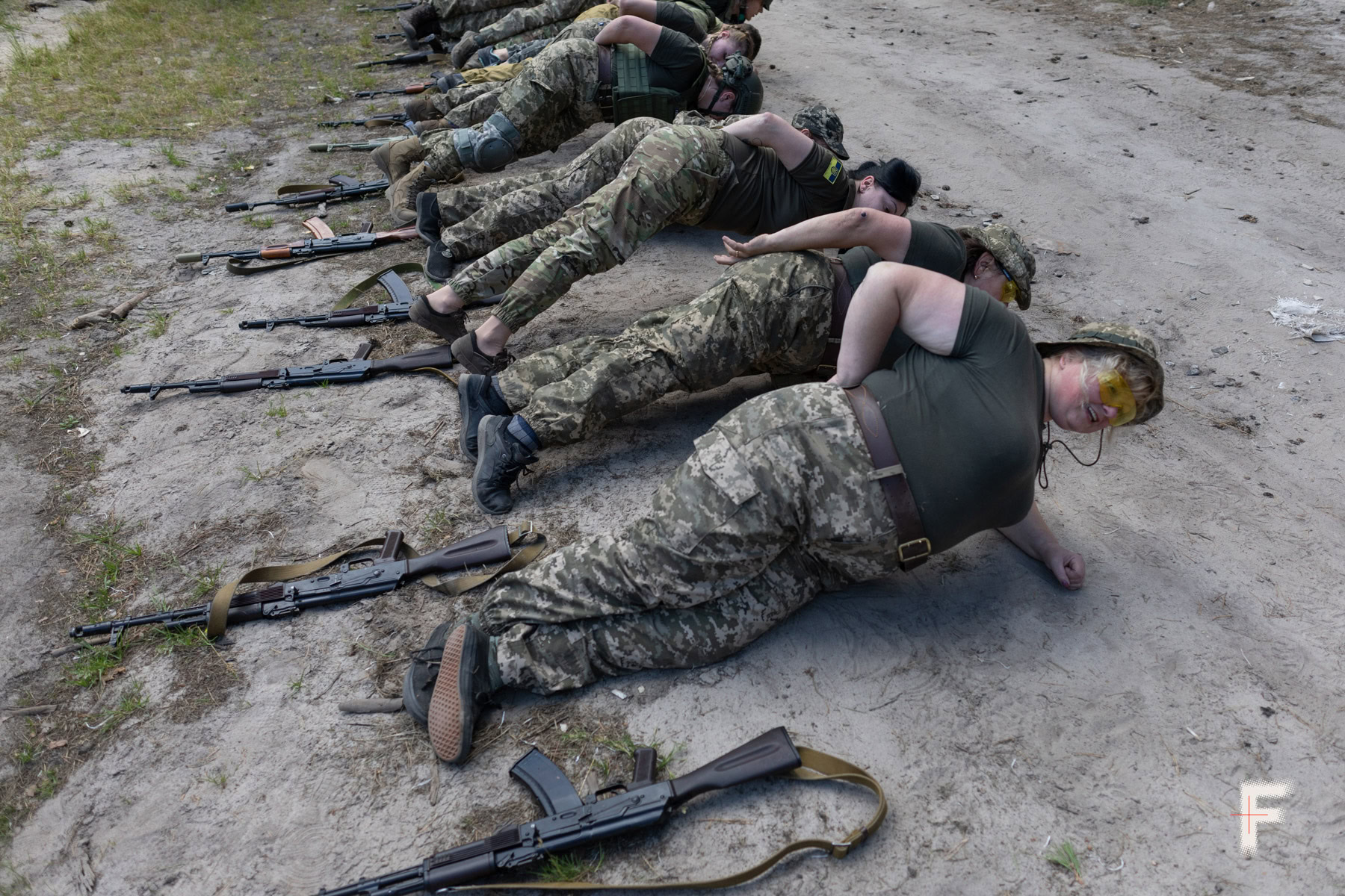 Жінки-добровольці стоять у боковій планці під час занять з тактичної підготовки